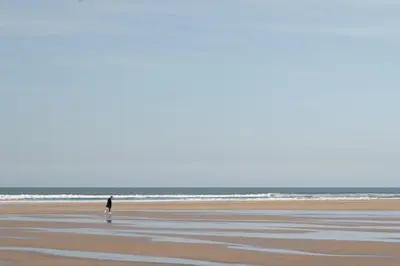 a person walking on the beach at Stylish Apartment Garden with Beautiful Sea Views in Newquay