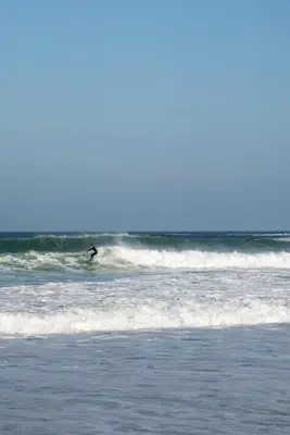 a person riding a wave on a surfboard in the ocean at Stylish Apartment Garden with Beautiful Sea Views in Newquay