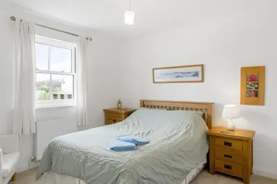 a bedroom with a bed with two towels on it at Homely Cottage & Garden nr Fowey Private Parking in Par