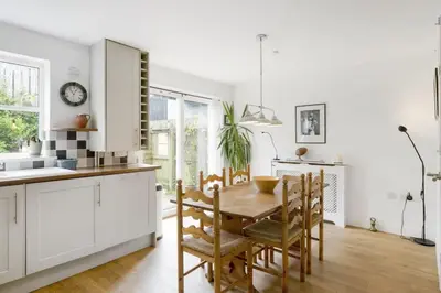 a kitchen with a table and chairs in a room at Homely Cottage & Garden nr Fowey Private Parking in Par