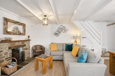 a living room with a couch and a fireplace at Beautiful Cottage Minutes from Mevagissey Harbour in Mevagissey