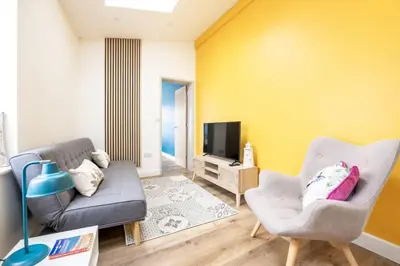 a living room with a couch and a tv at Stylish Apartment in Falmouth nr Seafront in Falmouth