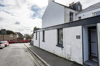 an empty parking lot next to a white building at Stylish Apartment in Falmouth nr Seafront in Falmouth