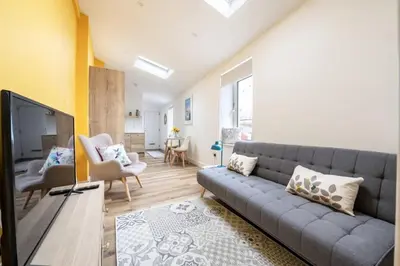 a living room with a couch and a tv at Stylish Apartment in Falmouth nr Seafront in Falmouth