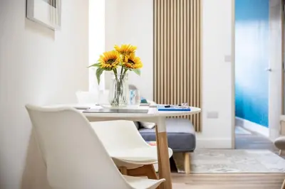 a dining room with a table with a vase of flowers at Stylish Apartment in Falmouth nr Seafront in Falmouth