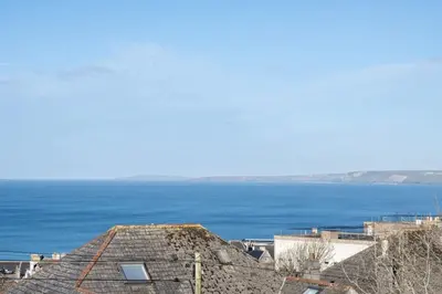 a view of the ocean from the roof of a building at Modern Mews Home with Sea Views Private Parking in Newquay
