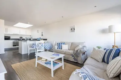 a living room with a couch and a table at Modern Home with Sea Views Newquay in Newquay