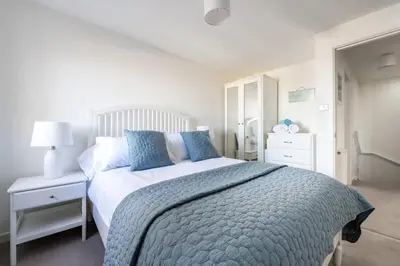 a bedroom with a large bed with a blue blanket at Modern Home with Sea Views Newquay in Newquay