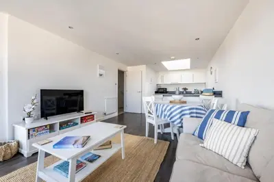 a living room with a couch and a table at Modern Home with Sea Views Newquay in Newquay