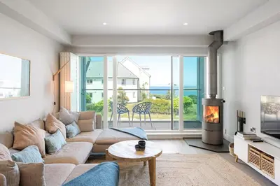 a living room with a couch and a fireplace at Contemporary Townhouse with Sea Views & Parking in Newquay