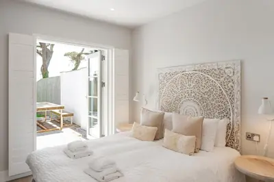 a white bedroom with a large bed with two towels on it at Contemporary Townhouse with Sea Views & Parking in Newquay