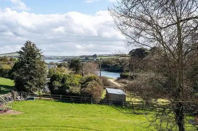 a view of a field with a river and trees at Stunning House with Estuary Views Padstow in Padstow