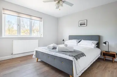 a white bedroom with a large bed and a window at Stunning House with Estuary Views Padstow in Padstow