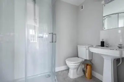 a white bathroom with a toilet and a sink at Stunning House with Estuary Views Padstow in Padstow