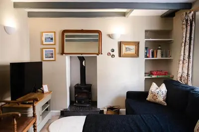 a living room with a couch and a wood stove at Smugglers Cottage in Penryn Nr Falmouth in Penryn