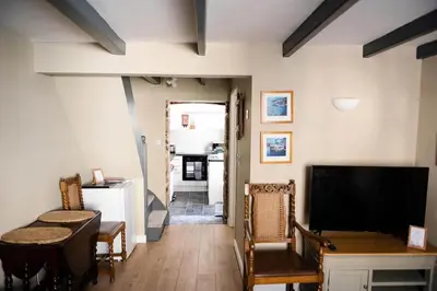 a living room with a television and a table and chairs at Smugglers Cottage in Penryn Nr Falmouth in Penryn