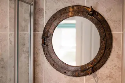 an old rusty mirror hanging on a wall at Smugglers Cottage in Penryn Nr Falmouth in Penryn