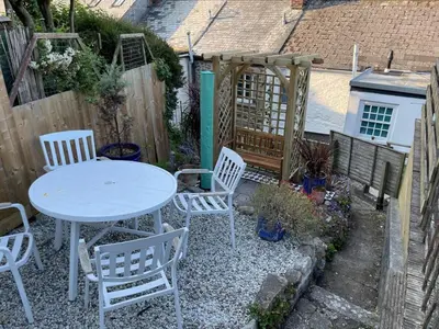 a white table and chairs in a garden at Smugglers Cottage in Penryn Nr Falmouth in Penryn