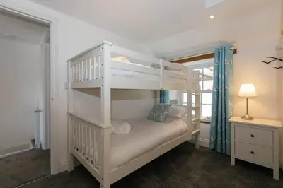 a white bunk bed in a room with a lamp at Homely Cottage with Sun Terrace Short Walk to Beach in Porthleven