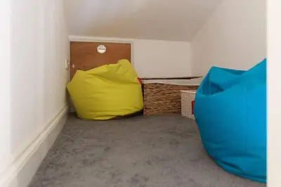 a room with a yellow pillow in the corner of a room at Homely Cottage with Sun Terrace Short Walk to Beach in Porthleven