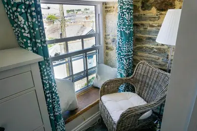 a room with two chairs and a window with a view at Homely Cottage with Sun Terrace Short Walk to Beach in Porthleven