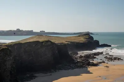 a beach with a rocky shoreline and the ocean at Beach-Style Flat 2 Min Walk to Tolcarne Beach in Newquay