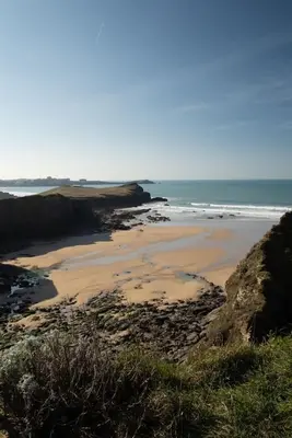a sandy beach with the ocean in the background at Beach-Style Flat 2 Min Walk to Tolcarne Beach in Newquay
