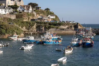 a group of boats in a body of water at Beach-Style Flat 2 Min Walk to Tolcarne Beach in Newquay