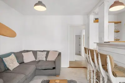 a living room with a couch and some chairs at Beach-Style Flat 2 Min Walk to Tolcarne Beach in Newquay