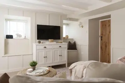 a living room with a tv on a white cabinet at Luxury Cottage with Parking Minutes to Beach and Restaurants in Porthleven