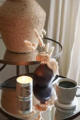 a table with a candle and some cups and a vase at Luxury Cottage with Parking Minutes to Beach and Restaurants in Porthleven