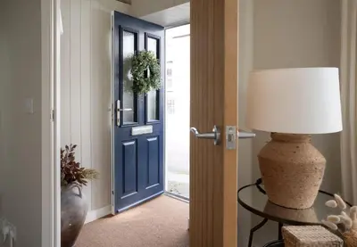 a room with a blue door and a table with a lamp at Luxury Cottage with Parking Minutes to Beach and Restaurants in Porthleven