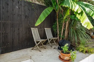 two chairs sitting on a patio next to a fence at Modern Townhouse in Central Falmouth Nr Seafront in Falmouth