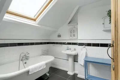 a bathroom with a sink and a bath tub and a sink at 18th Century Cottage with Garden Central Newquay in Newquay