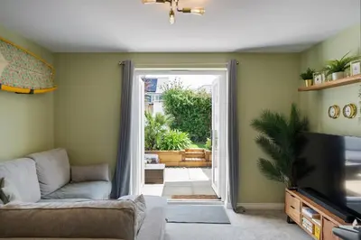 a living room with a couch and a television at Stylish Home with Private Parking & Garden in Newquay