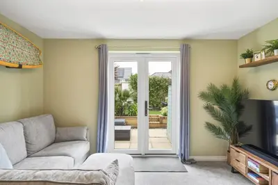 a living room with a couch and a sliding glass door at Stylish Home with Private Parking & Garden in Newquay