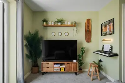 a living room with a television on a wooden entertainment center at Stylish Home with Private Parking & Garden in Newquay