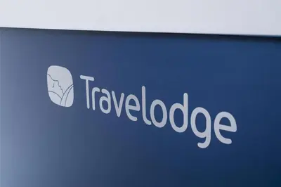 a sign for a travel loadage company on a wall at Travelodge St Austell in St Austell