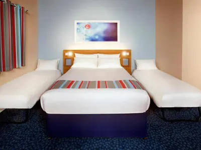 two beds in a hotel room with white beds at Travelodge Wadebridge in Wadebridge
