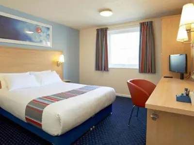 a hotel room with a bed and a desk at Travelodge Bodmin Roche in Roche