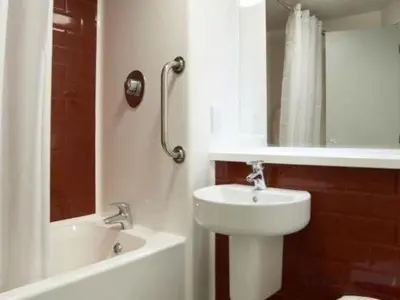 a bathroom with a sink and a toilet and a tub at Travelodge Bodmin Roche in Roche