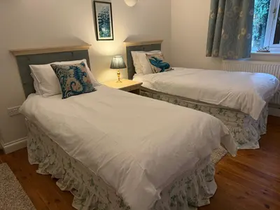 two beds with white sheets in a bedroom at Caldarvan in Wadebridge