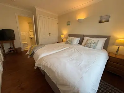 a bedroom with a large white bed with two pillows at Caldarvan in Wadebridge