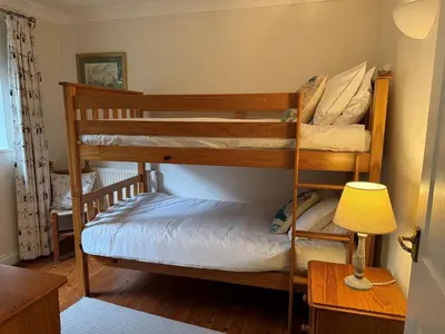 two bunk beds in a room with a lamp at Caldarvan in Wadebridge