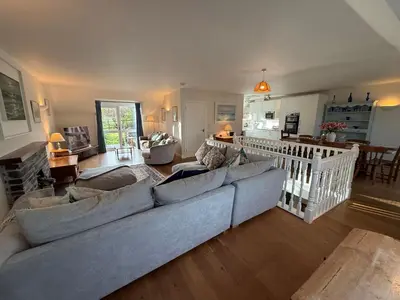 a living room with a large couch and a kitchen at Caldarvan in Wadebridge