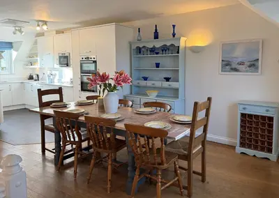a kitchen and dining room with a table and chairs at Caldarvan in Wadebridge