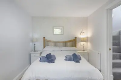 a bedroom with a white bed with towels on it at Beautiful Cottage on the Water Front Polruan in Polruan