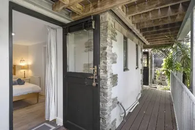 a door leading to a room with a bedroom at Beautiful Cottage on the Water Front Polruan in Polruan