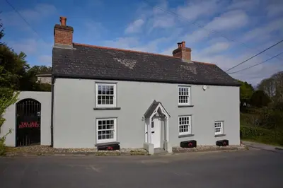 a white house on the side of a street at The Old Post Office Private Parking & Garden in Newquay