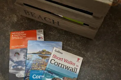 three books sitting on the floor next to a bench at The Old Post Office Private Parking & Garden in Newquay
